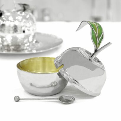 An apple-shaped silver honey dish with an enamel decoration